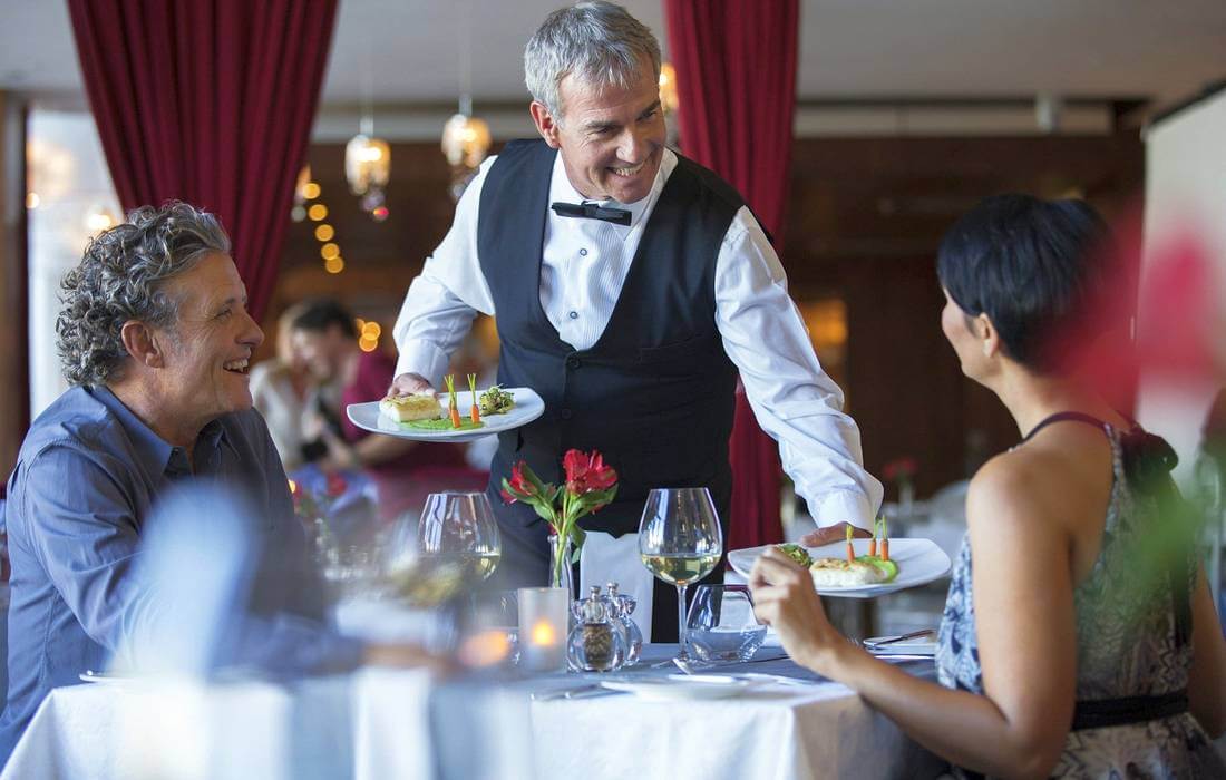 Photo of a couple who tip the waiter at a restaurant in the USA — American Butler